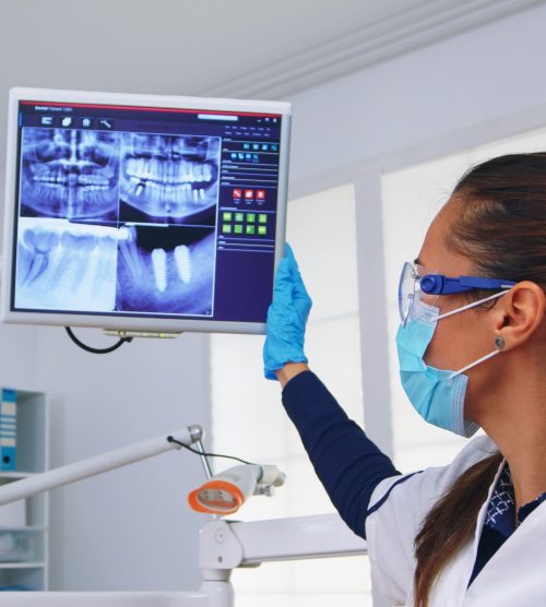 dentist-doctor-patient-looking-digital-teeh-x-ray-dental-office-person-pov-stomatology-wearing-protective-face-mask-gloves-pointing-teeth-radiography-stomatological-clinic (1)