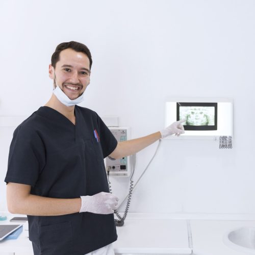 smiling-male-dentist-showing-dental-x-ray (1)