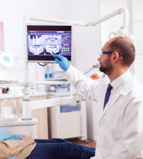 stomatolog-explaining-dental-treatment-senior-woman-examination-looking-x-ray-medical-teeth-care-taker-pointing-patient-radiography-screen-sitting-chair (1)